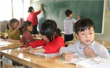  ?? Photo vov.vn ?? Two groups of students, from Grade 1 and Grade 2, study at the same classroom in Cà Lò School.