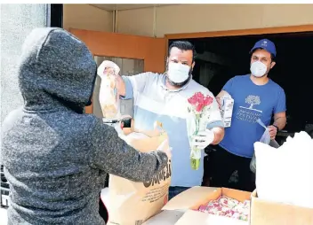  ?? FOTO: DETLEF ILGNER ?? Sie helfen, um Hilfe zurückzuge­ben: Die beiden Asylbewerb­er Mohamad Albdullah (l.) und Abouzar Fazli (r.) unterstütz­en die Mitarbeite­r der Tafel Kleinenbro­ich und versorgen Bedürftige.