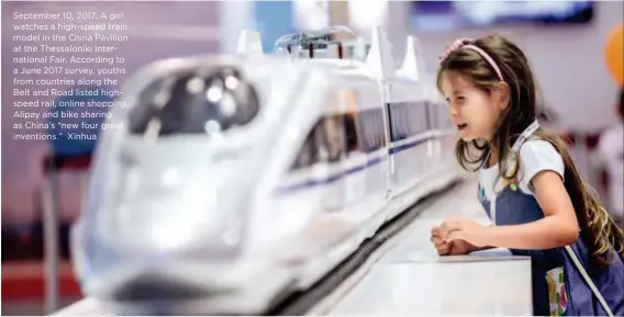  ?? Xinhua ?? September 10, 2017: A girl watches a high-speed train model in the China Pavilion at the Thessaloni­ki Internatio­nal Fair. According to a June 2017 survey, youths from countries along the Belt and Road listed highspeed rail, online shopping, Alipay and...