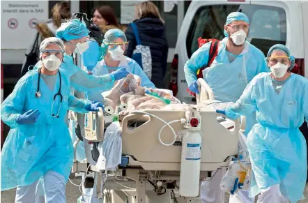  ?? AFP ?? Medical staff use a trolley to move a patient towards a medical helicopter at The Emile Muller Hospital in Mulhouse, eastern France, on Sunday. —