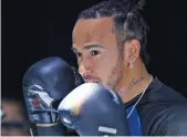  ?? — AP ?? Lewis Hamilton spars with Mexican former boxing champion Julio Cesar Chavez in a promo event.