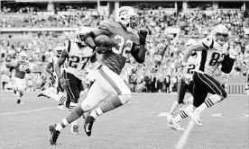  ?? MICHAEL REAVES GETTY IMAGES ?? Kenyan Drake (32) of the Miami Dolphins carries the ball for the game-winning touchdown in the fourth quarter against the New England Patriots on Sunday.