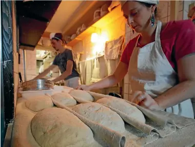  ?? PHOTO: REUTERS ?? The baker and his assistant work on bread doughs at Le Bricheton bakery in Paris.