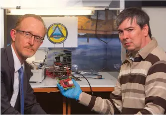  ??  ?? Andrew Dempster and Eamonn Glennon of the Australian Centre for Space Engineerin­g Research show a GPS module created for new defence satellites being made by Australia, the USA, Canada, the UK and New Zealand.