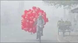  ?? SAMEER SEHGAL/HT ?? ■
A balloon-seller making his way through dense fog in Amritsar on Sunday.