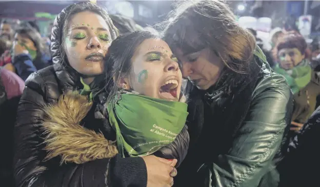  ?? PICTURE; GETTY IMAGES ?? 0 Activists in favour of the legalisati­on of abortion comfort each other outside the National Congress in Buenos Aires yesterday