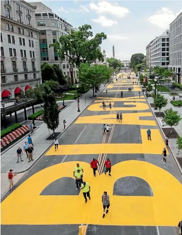  ?? AP ?? The Black Lives Matter sign painted in bright yellow letters on 16th Street by city workers and activists.