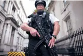  ?? DAN KITWOOD/GETTY IMAGES ?? A police officer stands guard Friday on Downing Street in London, England.