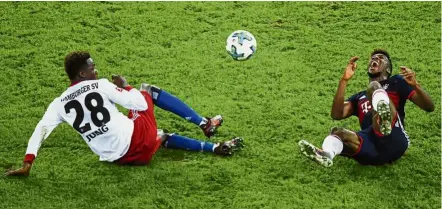  ??  ?? Bad collision: Bayern Munich’s Kingsley Coman (right) lies on the ground in pain after a tackle by Hamburg’s Gideon Jung on Saturday. — AP
