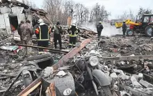  ?? AFP ?? Rescuers clear debris of homes destroyed by a Russian missile attack in the outskirts of Kyiv yesterday.