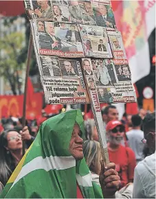  ?? Afp ?? INDIGNADOS. Un manifestan­te porta una pancarta con titulares sobre el presidente Temer publicado por diarios brasileños.