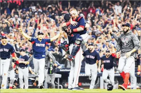  ?? HARRY HOW/GETTY IMAGES/AFP ?? Christian Vazquez jumps into the arms of Chris Sale of the Boston Red Sox to celebrate their 5-1 win over the Los Angeles Dodgers in Game 5 to win the 2018 World Series at Dodger Stadium on Sunday in Los Angeles, California.