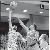  ?? AP/WILF THORNE ?? Houston’s Galen Robinson Jr. (25), with Arkansas’ Jaylen Barford defending, scored 2 points and had 3 rebounds, but also handed out 9 assists in the Cougars’ 91-65 victory over the Arkansas Razorbacks on Saturday night in Houston.