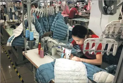  ?? MA ZHENHUAN / CHINA DAILY ?? Employees work at Jintongwan­g Dress Co in Zhili, Zhejiang province. The company produces one of China’s top brands of children’s clothing.