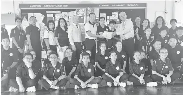  ??  ?? Huo (right) hands over the gifts to Rev Poh Chin Sing.