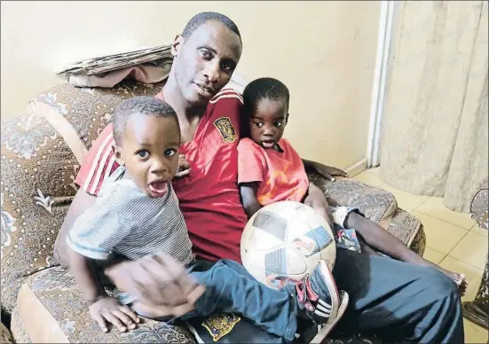  ?? ENRIQUE FIGUEREDO ?? Lima Diop M’Bengue sostiene en brazos a un hijo y a un sobrino en su casa del barrio de Parcelles Assainies, en Dakar