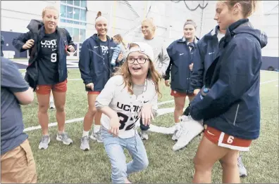  ?? MICHAEL MCANDREWS/SPECIAL TO THE COURANT ?? Eight-year-old Kaleigh Thereault of Manchester dances with her new UConn women’s lacrosse teammates after her letter of intent signing ceremony on the Storrs campus Tuesday. Kaleigh was made an honorary member of the women’s lacrosse team.