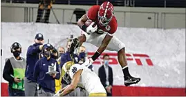  ?? MICHAEL AINSWORTH / AP ?? Alabama running back Najee Harris (22) hurdles Notre Dame cornerback Nick McCloud (4) as he carries the ball for a long gain in the first half of the Rose Bowl game in Arlington, Texas, on Friday.