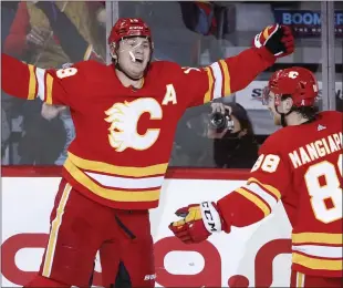  ?? CANADIAN PRESS PHOTO ?? Calgary Flames Matthew Tkachuk celebrates his 40th goal and his 100th point of the season with teammate left wing Andrew Mangiapane during second period NHL hockey action against the Dallas Stars in Calgary on Thursday.