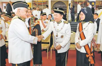  ??  ?? Taib (left) greets members of Sarawak Legislativ­e Assembly before departing from the DUN Complex after the opening ceremony.