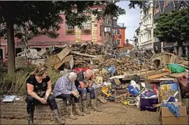  ?? Bram Janssen Associated Press ?? PEOPLE REST while cleaning up July 19 after deadly flooding tore through the German district of Ahrweiler. Some towns’ sirens failed; others had none at all.
