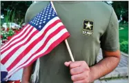  ?? AP FILE PHOTO BY MIKE KNAAK ?? In this July 3, photo, a Pakistani recruit, 22, who was recently discharged from the U.S. Army, holds an American flag as he poses for a picture.