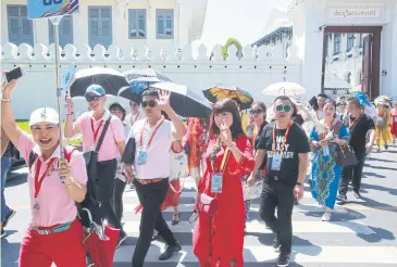  ??  ?? A tour guide leads Chinese tourists from the Grand Palace in 2018. The TAT expects mainland tourists to resume travel activity within China in April.