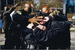  ?? MARK HUMPHREY — THE ASSOCIATED PRESS ?? Nashville Police Chief John Drake joins a group of police officers as they embrace after speaking at a news conference Sunday in Nashville, Tenn.