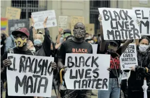  ?? Picture: LLUIS GENE/AFP ?? SOLIDARITY: Protesters hold placards reading 'Black Lives Matter' and 'Racism kills' in Barcelona yesterday during a demonstrat­ion against racism, in the wake of the killing of George Floyd in the US.
