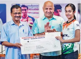  ?? — PTI ?? Delhi CM Arvind Kejriwal presents a cheque to an athlete under ‘Mission Excellence Scheme’ in New Delhi. Deputy CM Manish Sisodia is also seen.