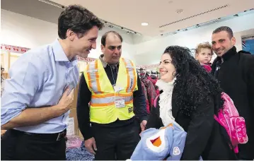  ?? NATHAN DENETTE / THE CANADIAN PRESS ?? Prime Minister Justin Trudeau greets Syrian refugees arriving at Toronto’s Pearson Internatio­nal Airport in December 2015. The numbers admitted by Canada are tiny compared to Lebanon, Jordan and Turkey.