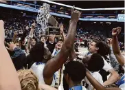  ?? Dennis Lee/SBLive Sports ?? Oakland Tech players hoist the Division 2 state title trophy after taking down Centennial 79-55.