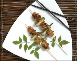  ?? PHOTO BY NICK KOON ?? Chicken and green onion yakitori skewers are grilled with sauce made from soy, sake, mirin, sugar, ginger, garlic and chopped green onion.