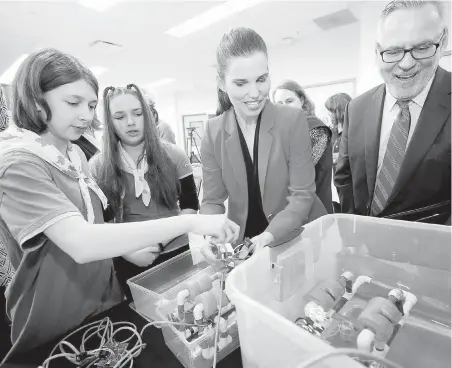  ??  ?? Science Minister Kristy Duncan and Pierre Normand, vice-president of the Canada Foundation for Innovation, take a look at a battery-operated underwater submersibl­e with Pathfinder­s Naomi Schoeck, 12, left, and Josie Zemanek, 14, at the University of...