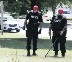  ?? VERONICA HENRI / POSTMEDIA NEWS ?? Police investigat­e at the scene of a double killing in a suburban Toronto-area neighbourh­ood on Friday.