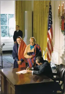  ?? ROBERT L. KNUDSEN/WHPO - Richard Nixon Presidenti­al Library and Museum ?? President Richard Nixon signing the Blue Lake bill, HR 471, deeding lands to Taos Pueblo. Beside him are tribal leaders Paul Bernal, left, and Cacique Juan de Jesus Romero, center. December 15, 1970.