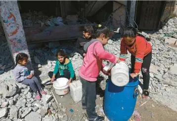  ?? MOHAMMED ABED/GETTY-AFP ?? Children fetch water Friday in Rafah, a border city in the southern Gaza Strip. “Our life has become a nightmare,” says Hadeel Abu Sharek, 24, whose family and other relatives fled from northern Gaza when the war began.