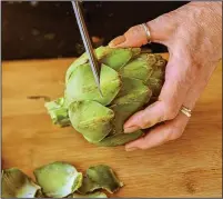  ??  ?? Snipping the thorny ends off of an artichoke’s leaves with kitchen shears will make it easier to handle.