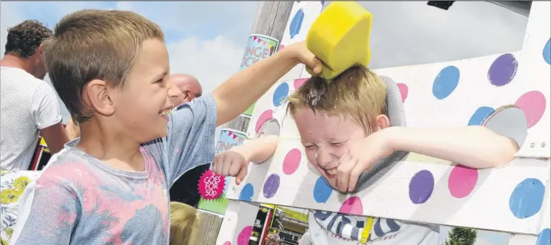  ?? FM4813553 ?? Steven Hopkin, 10, was in the stocks and got a soaking from Josh Coot, nine, at Goat Lees Primary School fete Pictures: Paul Amos