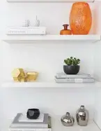  ??  ?? This bookshelf in a home designed by architect Tanya Hancock from TO1 Architectu­re is filled with carefully selected objects. The palette is deliberate­ly simple with white, silver and metallics. An orange pop of colour brings the whole look to life.