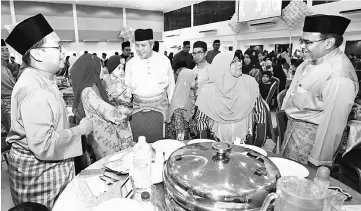  ??  ?? Awang Tengah (third left) together with Hasbi (right) wishing guests Selamat Hari Raya Aidilfitri at the event yesterday. — Photo by Muhammad Rais Sanusi
