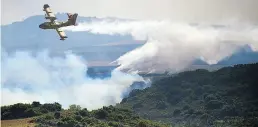  ?? Dpa-BILD: Oses ?? Ein Löschflugz­eug wirft ein Feuerschut­zmittel auf ein brennendes Gebiet in Nordspanie­n ab.