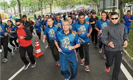  ??  ?? Keeping fit: Mohamad Fuzi (centre) participat­ing in the 5km run held in conjunctio­n with the National Sports Day 2018 celebratio­n at Puteri Harbour in Iskandar Puteri, Johor.