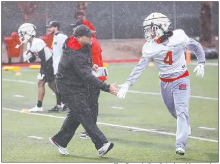  ?? Chase Stevens Las Vegas Review-journal @csstevensp­hoto ?? UNLV coach Barry Odom greets defensive back Jerrae Williams on the first day of spring practice.