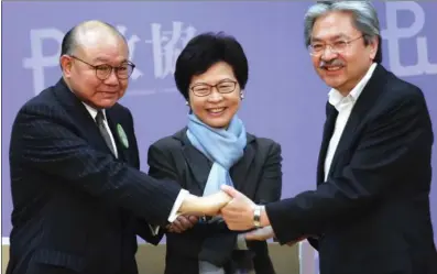  ?? PARKER ZHENG / CHINA DAILY ?? Chief Executive election candidates Carrie Lam Cheng Yuet-ngor (center), John Tsang Chun-wah (right) and Woo Kwok-hing join hands before a forum organized by the Hong Kong Profession­al Teachers’ Union on Sunday. It was the first forum all three CE...