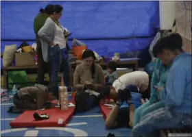  ?? MARCO UGARTE — THE ASSOCIATED PRESS ?? Relatives of people being treated for earthquake-related injuries use a shelter set up across the street from the General Xoco Hospital where their loved ones are being treated in Mexico City, Saturday. As rescue operations stretched into Day 5,...