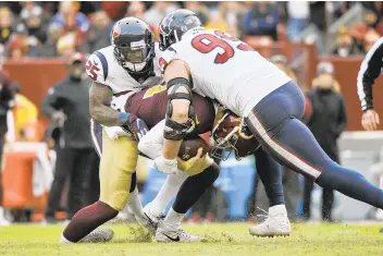  ?? MARK TENALLY/AP ?? Washington Redskins quarterbac­k Alex Smith’s ankle is injured as he is sacked by Houston Texans defensive end J.J. Watt (99) and Houston Texans strong safety Kareem Jackson on Nov. 18.