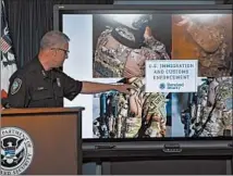  ?? SAMUEL CORUM/GETTY ?? Richard Cline, of the Federal Protective Service, on Tuesday points to markings worn by agents deployed in Portland, Oregon.