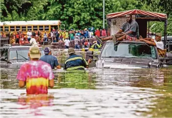  ?? Michael Ciaglo photos / Houston Chronicle ?? Good Samaritans who were trying to rescue others from the flooding in the Greenspoin­t area last week were forced to take shelter on top of their truck after it got stranded on Seminar Drive.