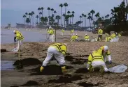  ?? Ringo H.W. Chiu / Associated Press 2021 ?? Workers clean the contaminat­ed beach in Corona del Mar (Orange County) after an oil spill on Oct. 7.